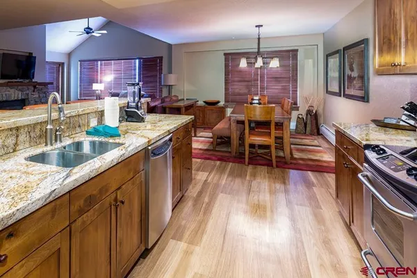 a kitchen with sink stove and wooden floor