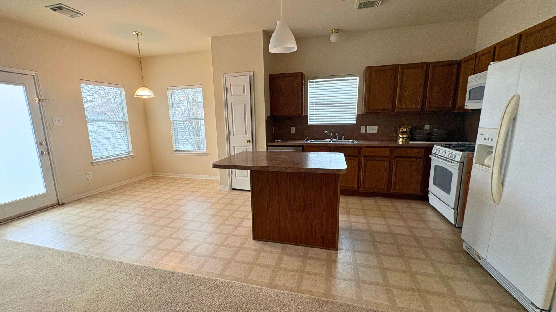 21842 Grassy Hill Lane Spring, TX 77388 - Photo 2 of 9 a large kitchen with granite countertop a stove a refrigerator and a sink