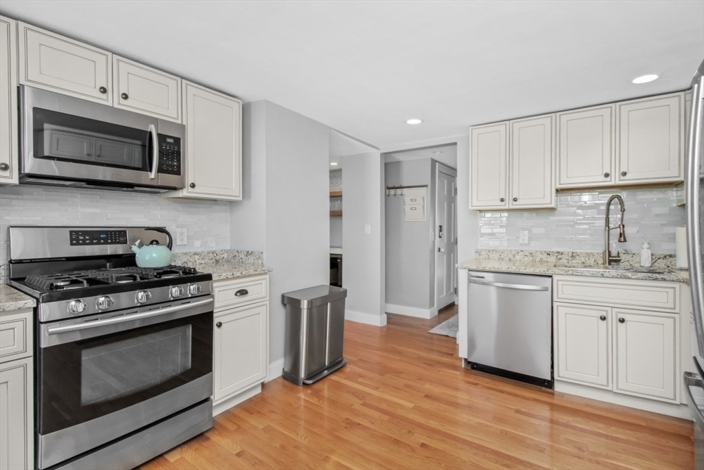 16 Port Norfolk Street, Unit 2 Boston, MA 02122 - Photo 6 of 20 a kitchen with stainless steel appliances white cabinets a stove a sink and a microwave