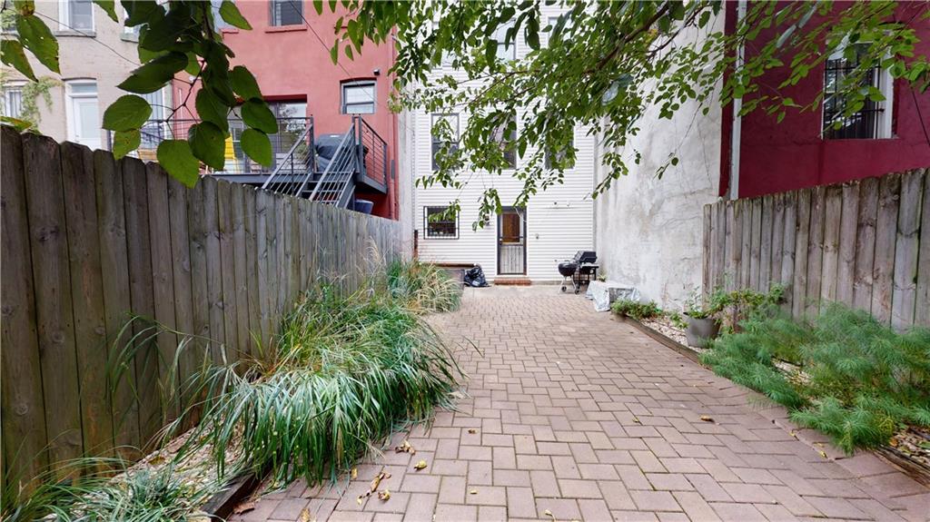 722 Madison Street Brooklyn, NY 11221 - Photo 12 of 29 a view of a backyard with potted plants and a large tree
