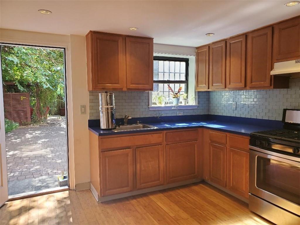 722 Madison Street Brooklyn, NY 11221 - Photo 9 of 29 a kitchen with stainless steel appliances granite countertop wooden cabinets a sink and a large window