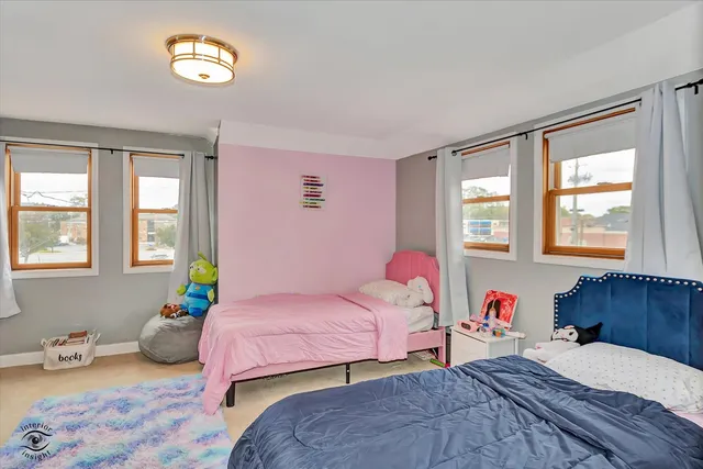 a bedroom with a bed and a flat tv screen on dresser