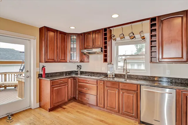 a kitchen with stainless steel appliances granite countertop a stove a sink and a microwave