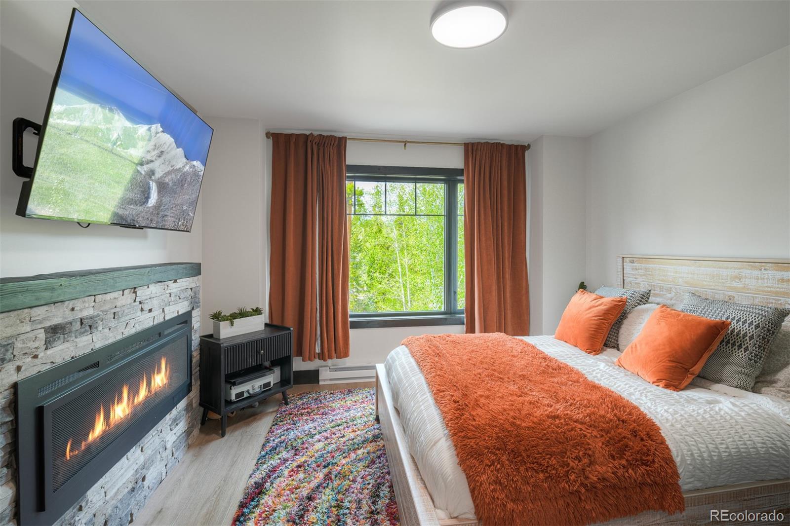 306 Golden Eagle Road Silverthorne, CO 80498 - Photo 23 of 43 a bedroom with a bed and a fireplace