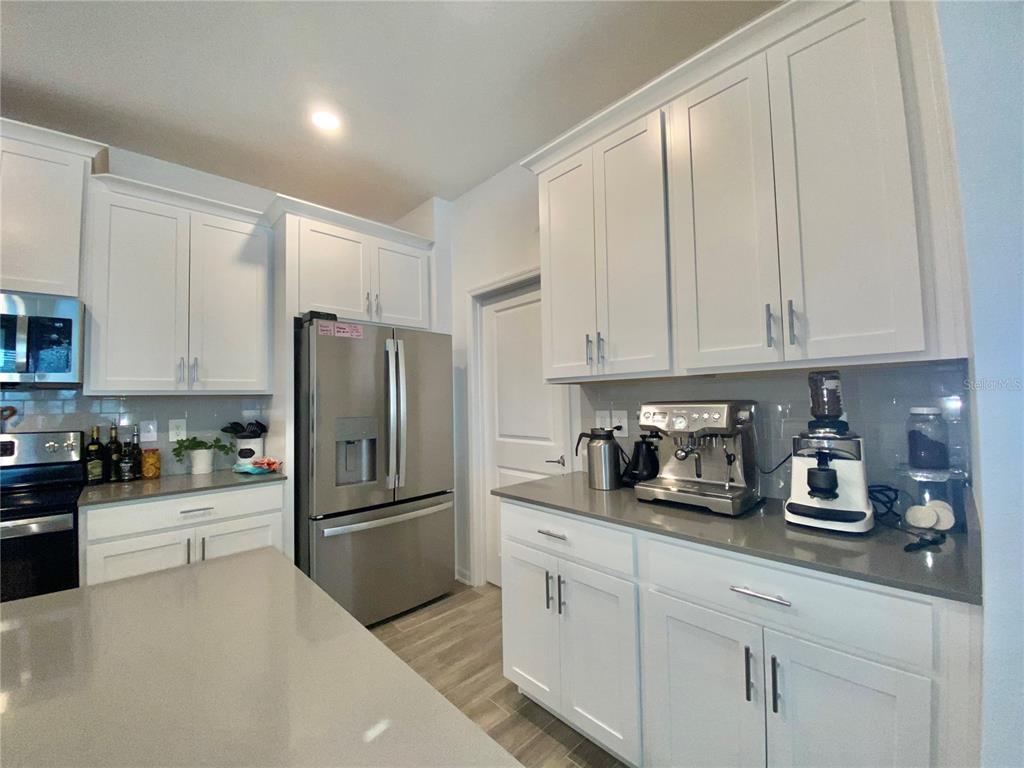 a kitchen with refrigerator a stove and cabinets