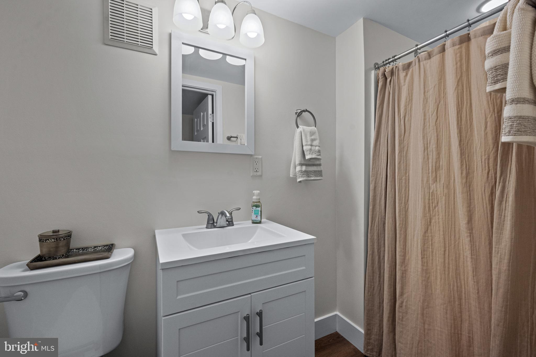 6226 2nd Avenue Hanover, MD 21076 - Photo 27 of 48 a bathroom with a sink a mirror and a toilet
