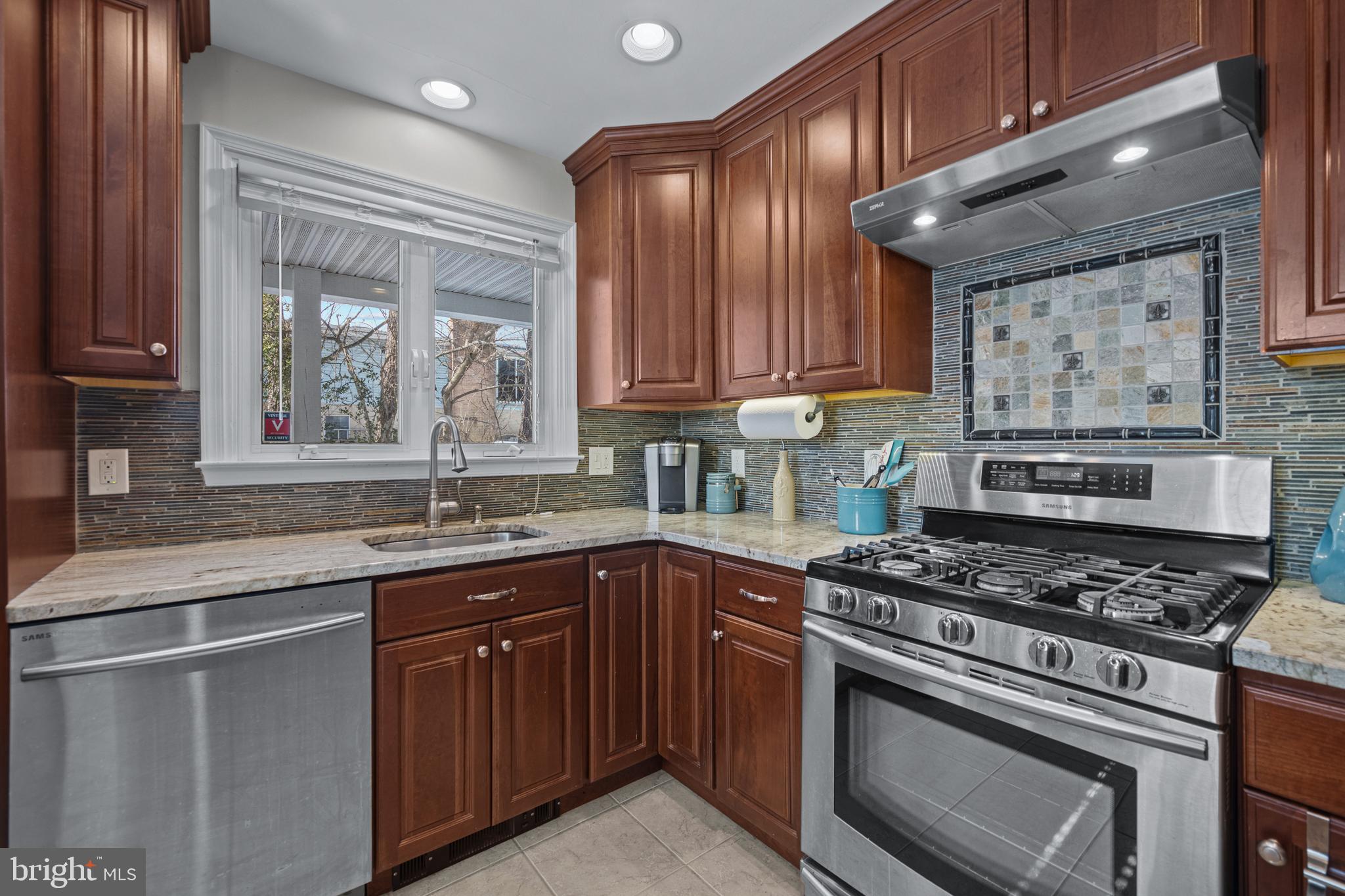 6226 2nd Avenue Hanover, MD 21076 - Photo 9 of 48 a kitchen with granite countertop stainless steel appliances a stove sink and cabinets