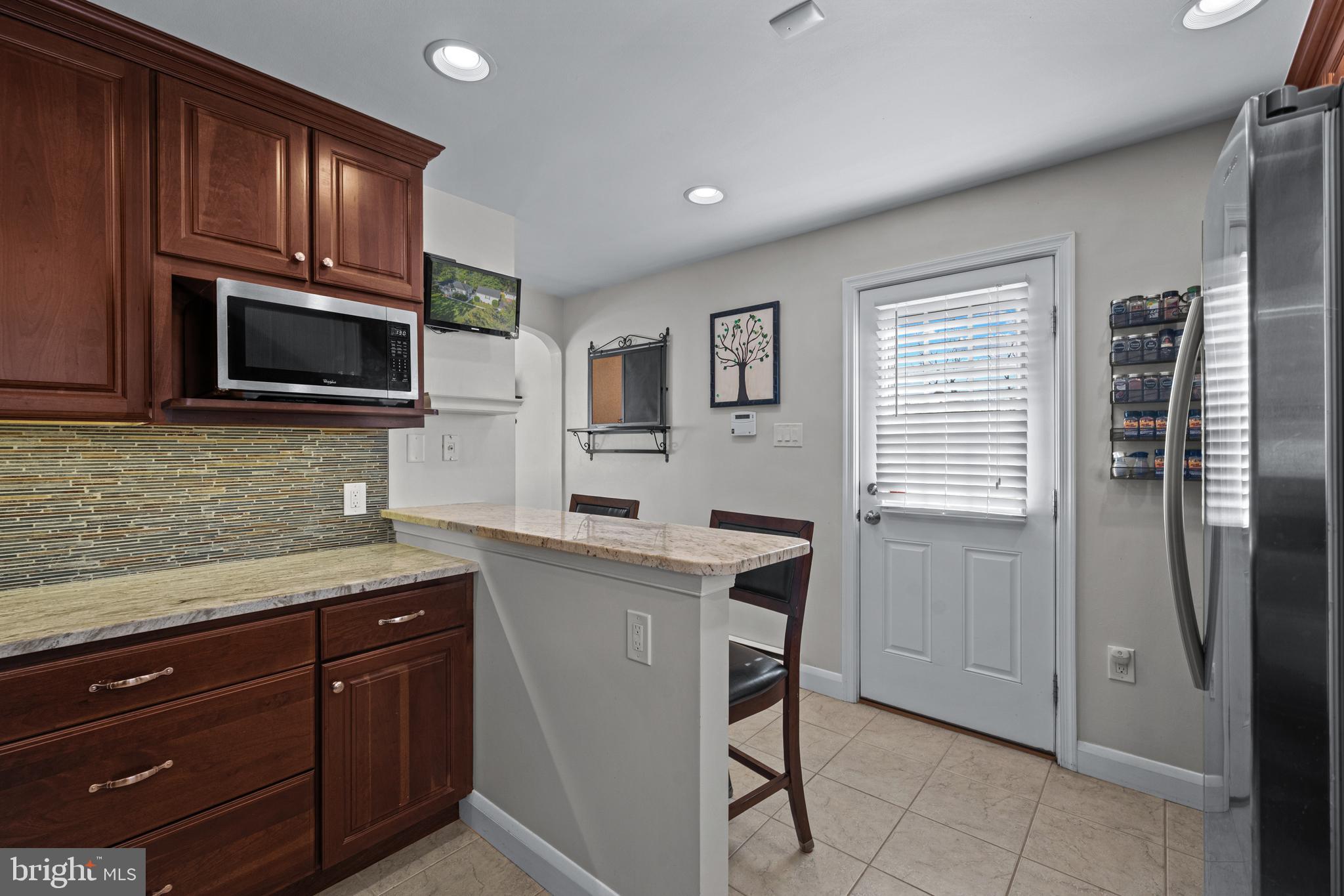 6226 2nd Avenue Hanover, MD 21076 - Photo 10 of 48 a kitchen with granite countertop wooden cabinets stainless steel appliances and a window