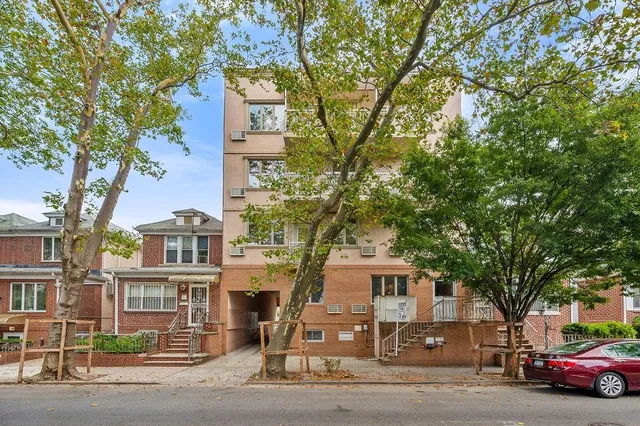 a front view of a residential apartment building with a yard
