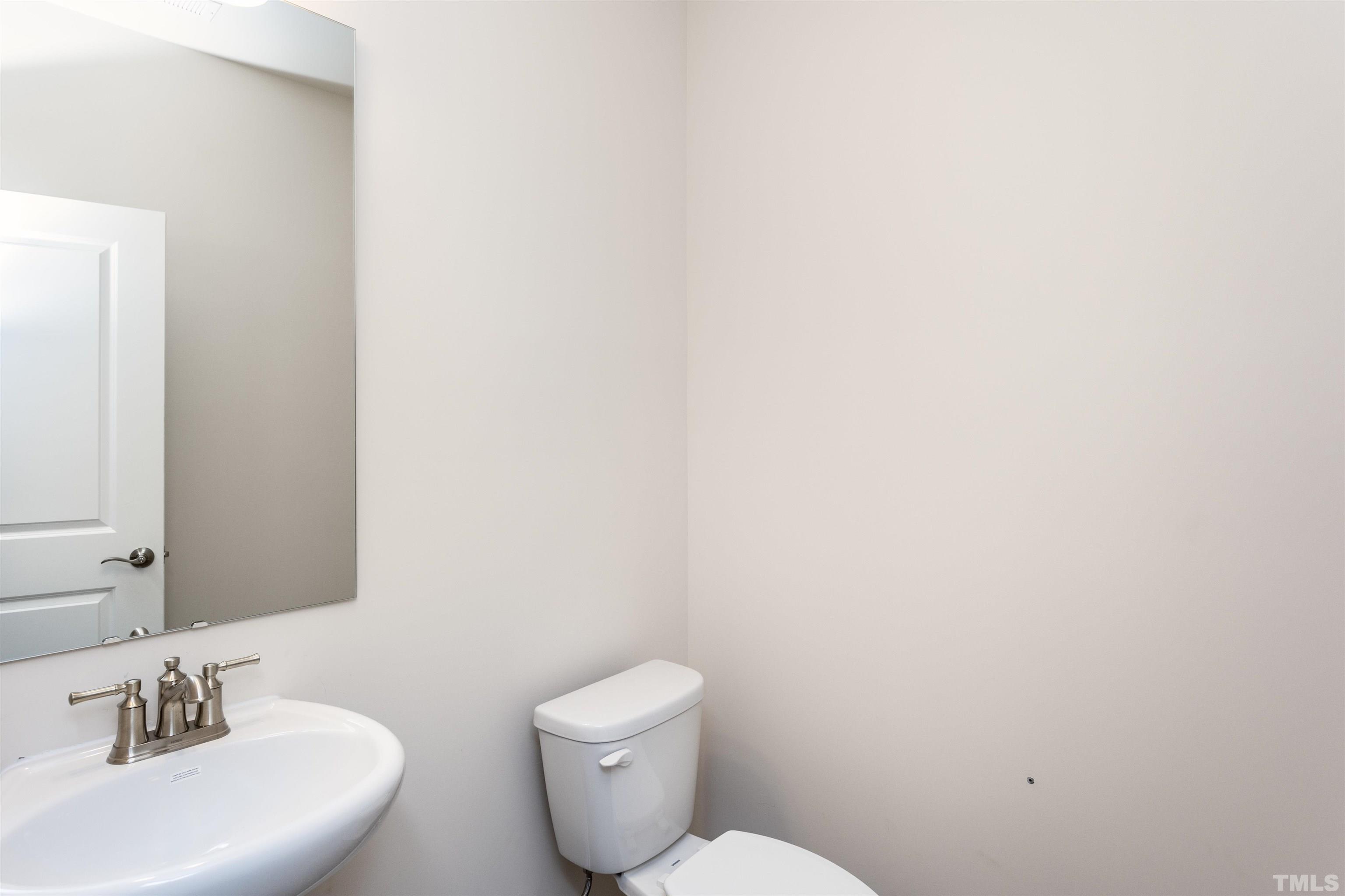5716 Preveza Place Raleigh, NC 27603 - Photo 13 of 23 a bathroom with a toilet a sink and mirror