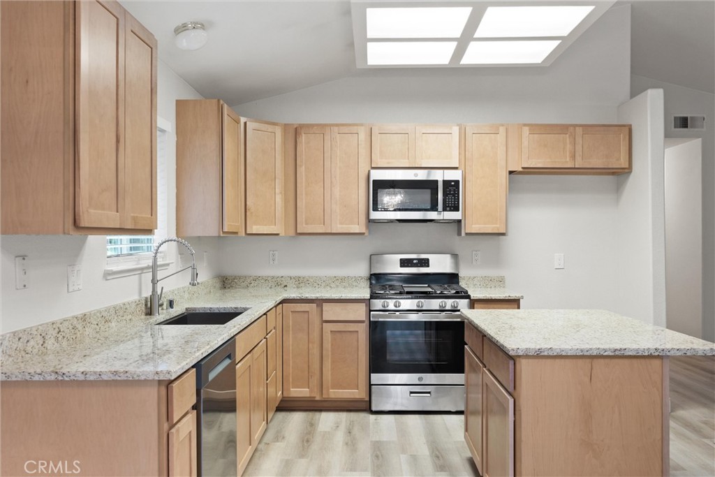 1165 Fig Street Corning, CA 96021 - Photo 12 of 46 a kitchen with stainless steel appliances granite countertop a sink stove and microwave
