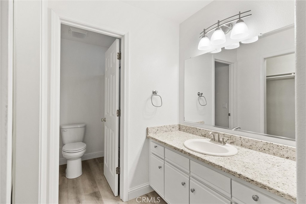 1165 Fig Street Corning, CA 96021 - Photo 19 of 46 a bathroom with a granite countertop sink a toilet and a mirror