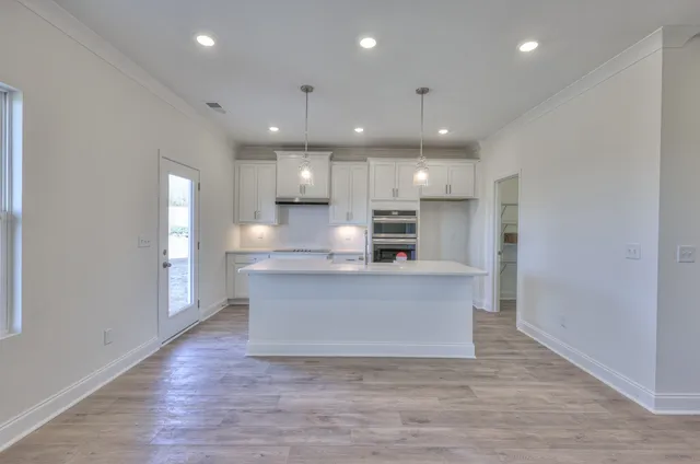 a view of kitchen with kitchen island and stainless steel appliances