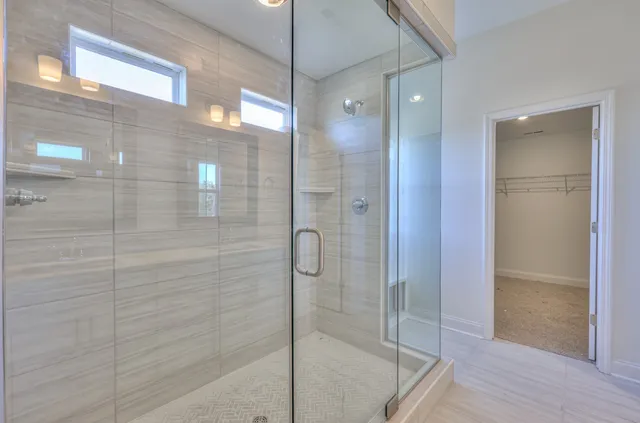 a bathroom with a glass shower door and a sink