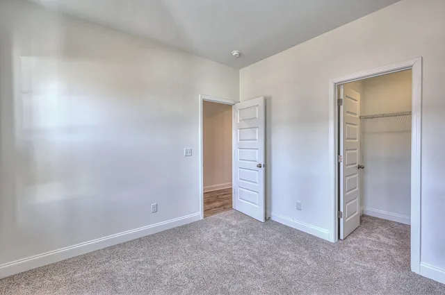an empty room with closet and a bathroom