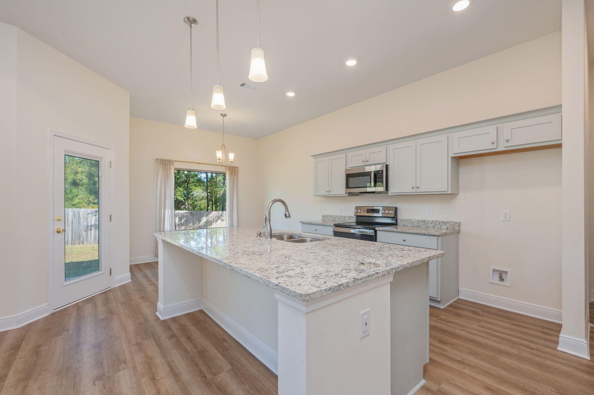 10152 American Farms Road Milton, FL 32583 - Photo 12 of 49 a kitchen with stainless steel appliances granite countertop a sink dishwasher and a stove with wooden floor