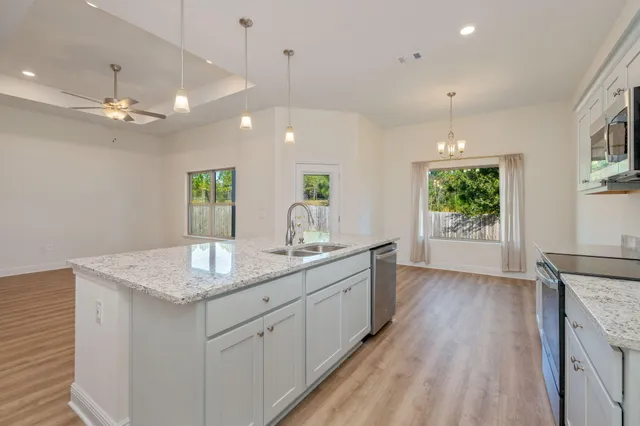 a open kitchen with kitchen island a counter space a sink and a window