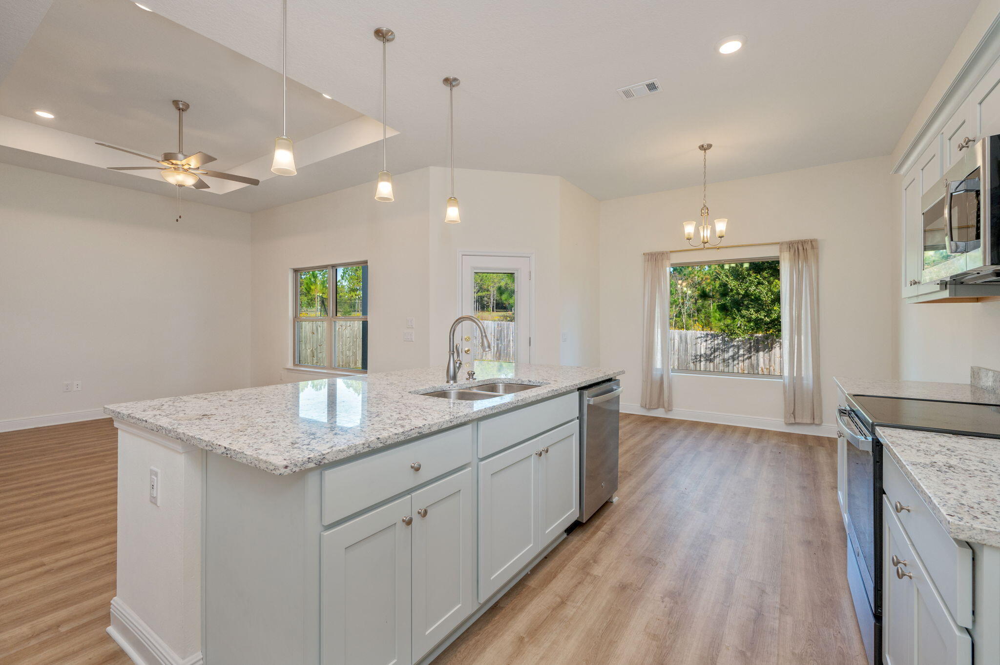 10152 American Farms Road Milton, FL 32583 - Photo 14 of 49 a open kitchen with kitchen island a counter space a sink and a window
