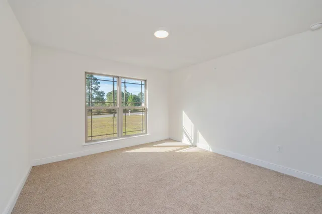 a view of an empty room with a window and closet area