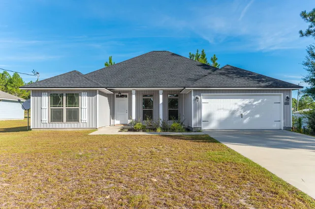 a front view of a house with a garden and yard