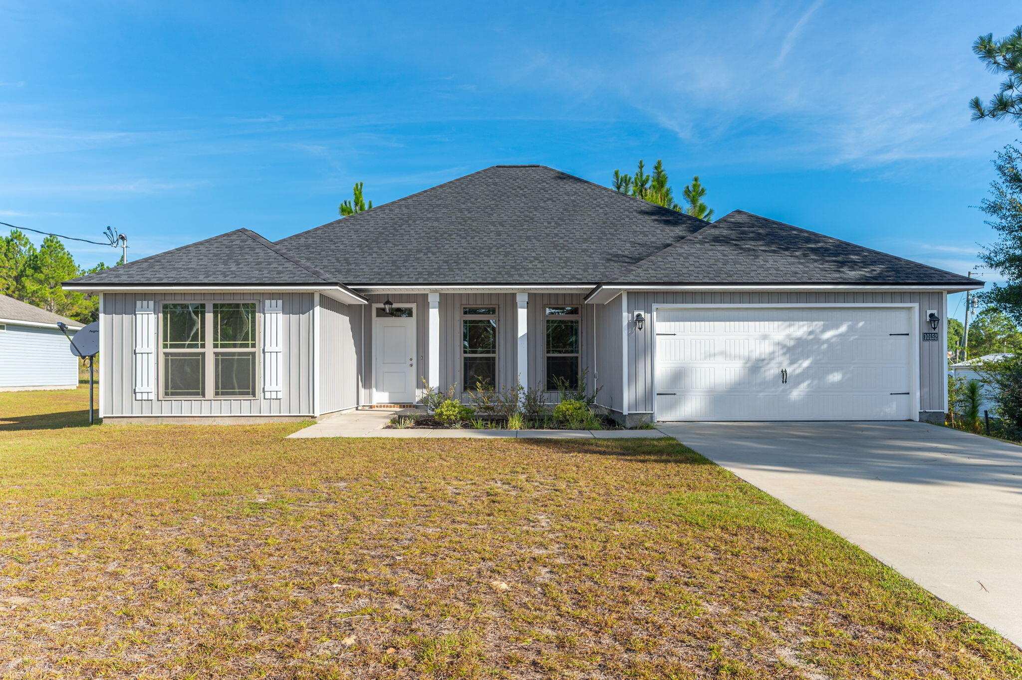 10152 American Farms Road Milton, FL 32583 - Photo 4 of 49 a front view of a house with a garden and yard