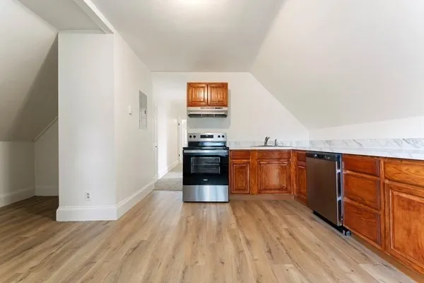 a kitchen with granite countertop a refrigerator and a stove top oven