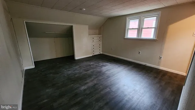 an empty room with wooden floor and closet
