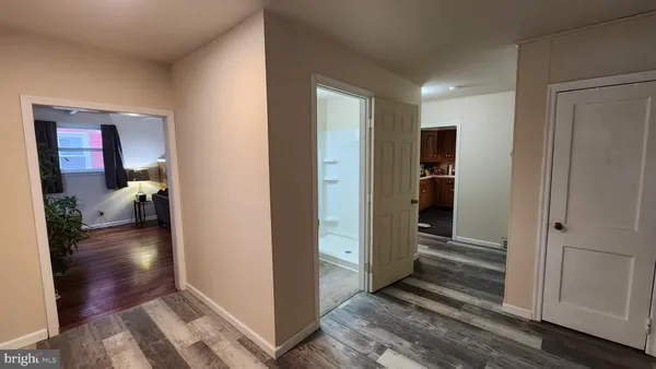 a view of a hallway with wooden floor and closet