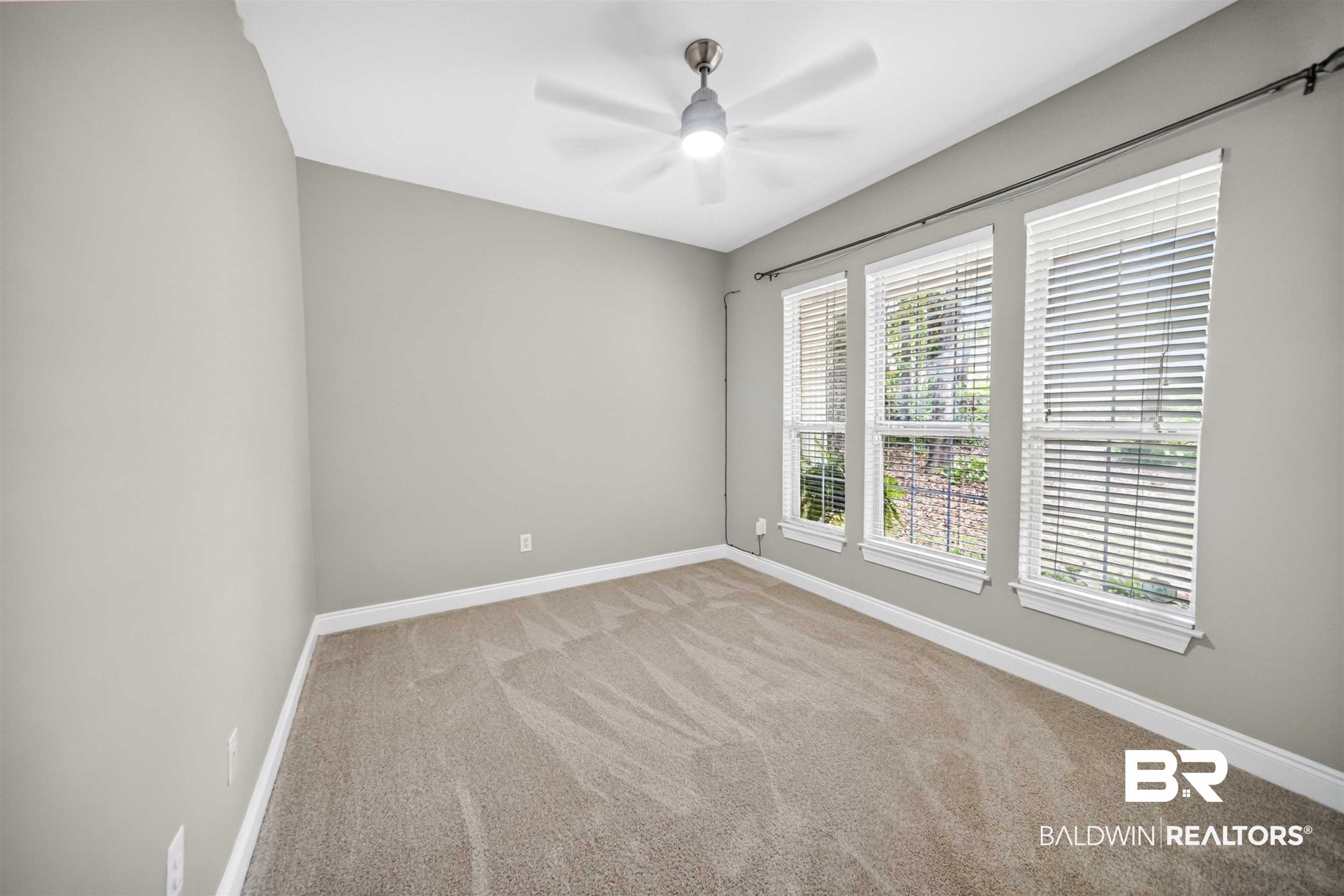 5913 Antoine Road Mobile, AL 36693 - Photo 22 of 33 Room featuring three vertical windows with blinds, light gray wall paint, and brown patterned carpeting