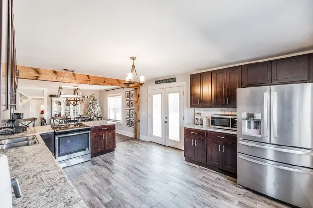 a kitchen with stainless steel appliances kitchen island granite countertop a refrigerator stove and oven