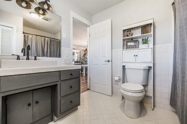 a bathroom with a granite countertop toilet sink and mirror