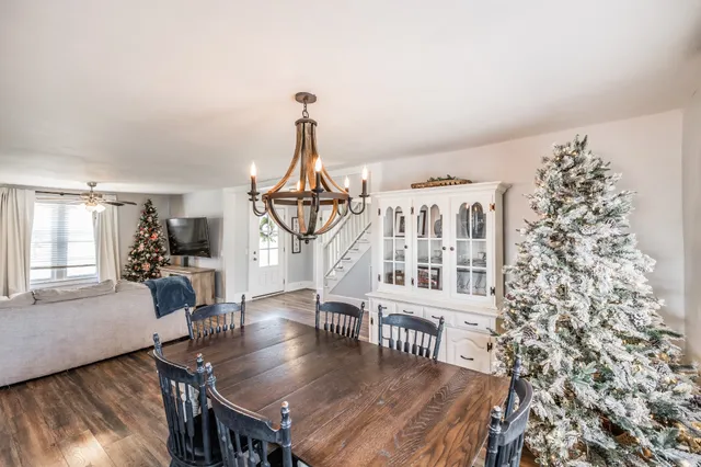 a view of a livingroom with furniture wooden floor windows and a chandelier