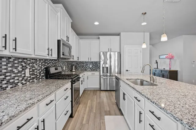 a kitchen with stainless steel appliances granite countertop a sink stove and refrigerator