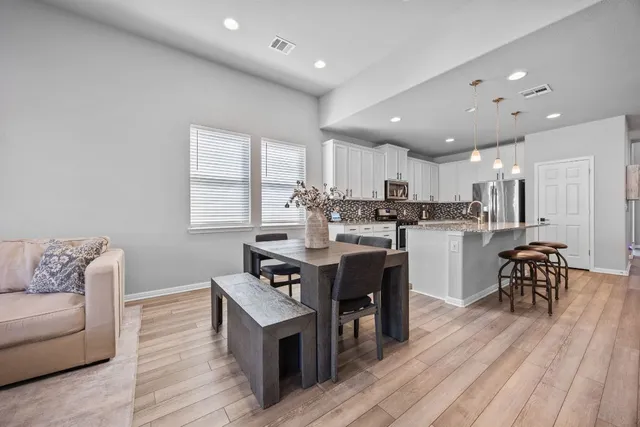 a open kitchen with kitchen island a sink a stove a dining table and chairs