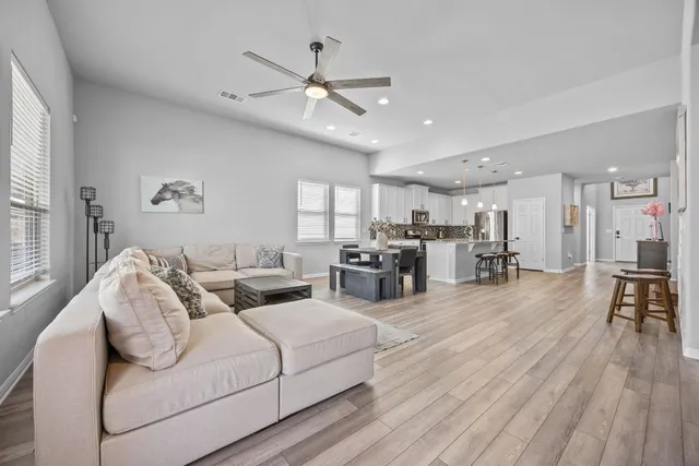 a living room with furniture and a wooden floor