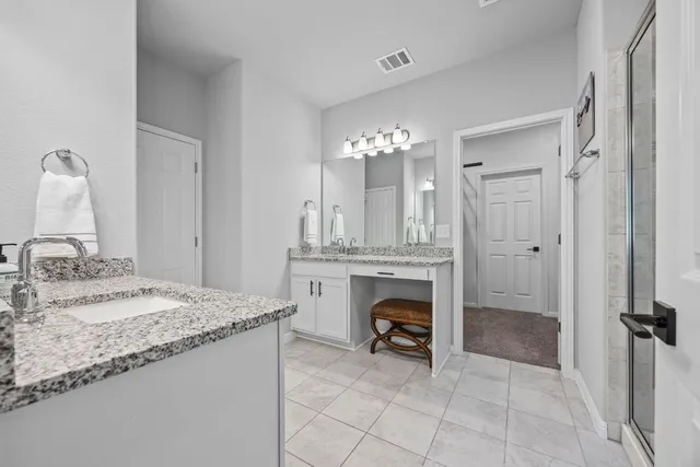 a bathroom with a granite countertop sink a toilet and a mirror
