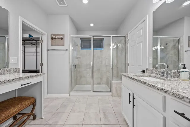 a spacious bathroom with a granite countertop sink a toilet a mirror and shower