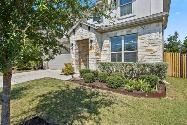 a view of a house with brick walls and flower plants