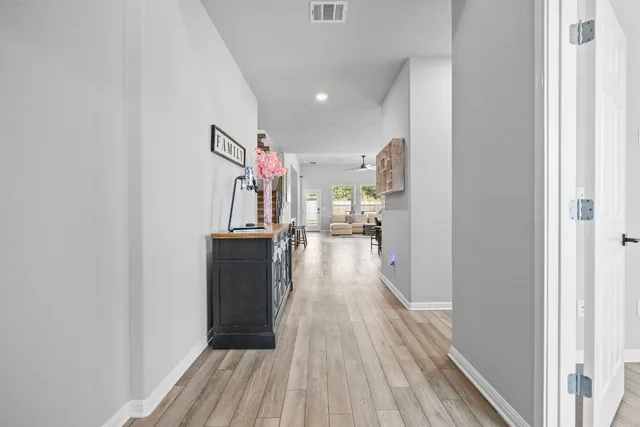 a view of a hallway view with wooden floor and electronic appliances