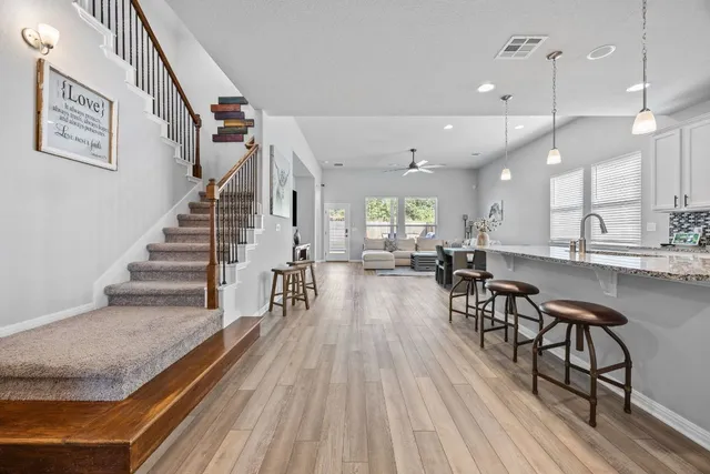 a dining hall with wooden floor and large windows