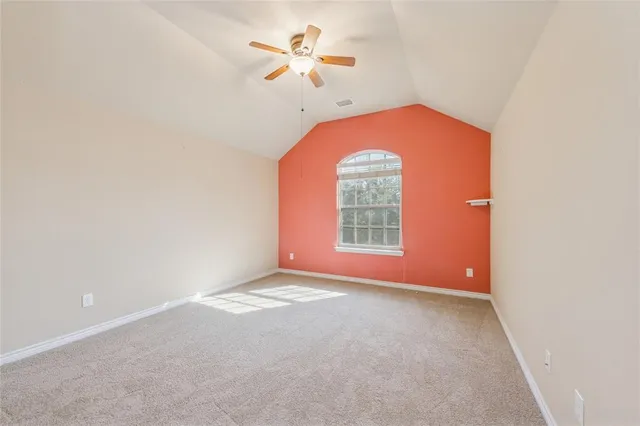 an empty room with a window and a ceiling fan
