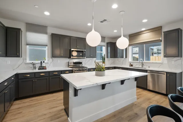 a kitchen with lots of counter space a sink and appliances