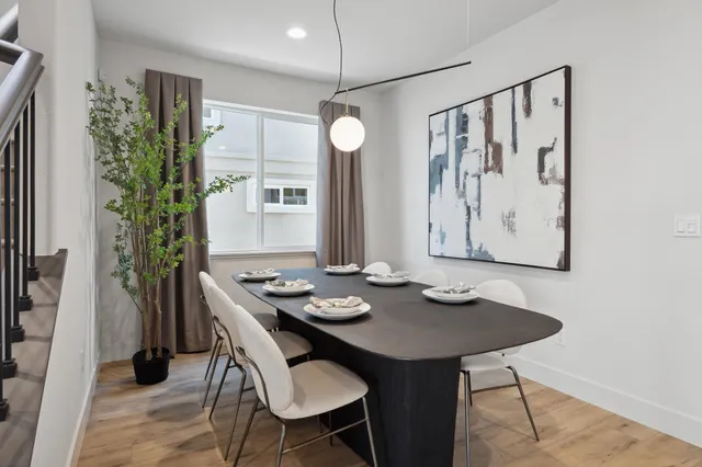 a kitchen with stainless steel appliances kitchen island granite countertop a table chairs sink and cabinets