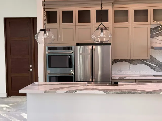 a living room with stainless steel appliances kitchen island granite countertop furniture and a fireplace