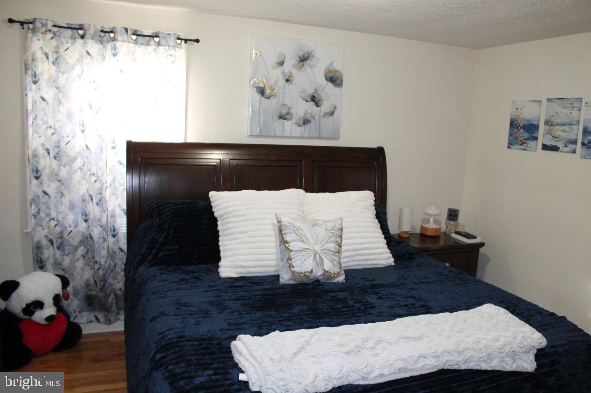 117 West Oates Avenue Winchester, VA 22601 - Photo 8 of 17 a bed sitting in a bedroom next to a bathroom with a shower