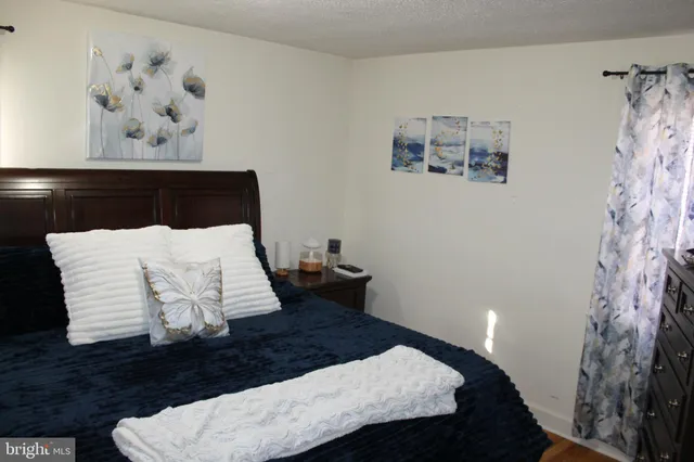 a bedroom with a bed and painting on the wall