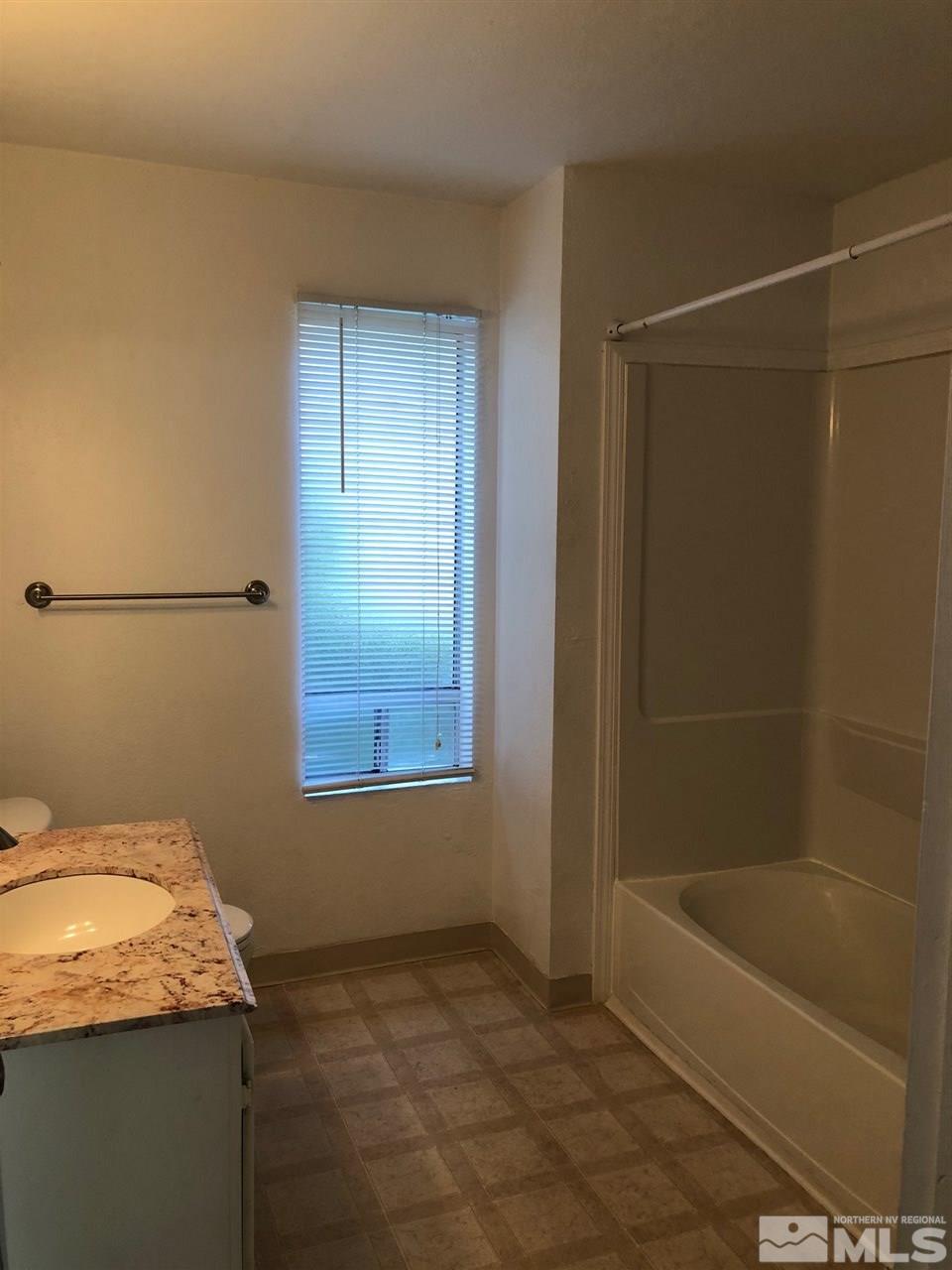 3942 Clear Acre Lane Reno, NV 89512 - Photo 18 of 24 a bathroom with a granite countertop sink a mirror and a bathtub