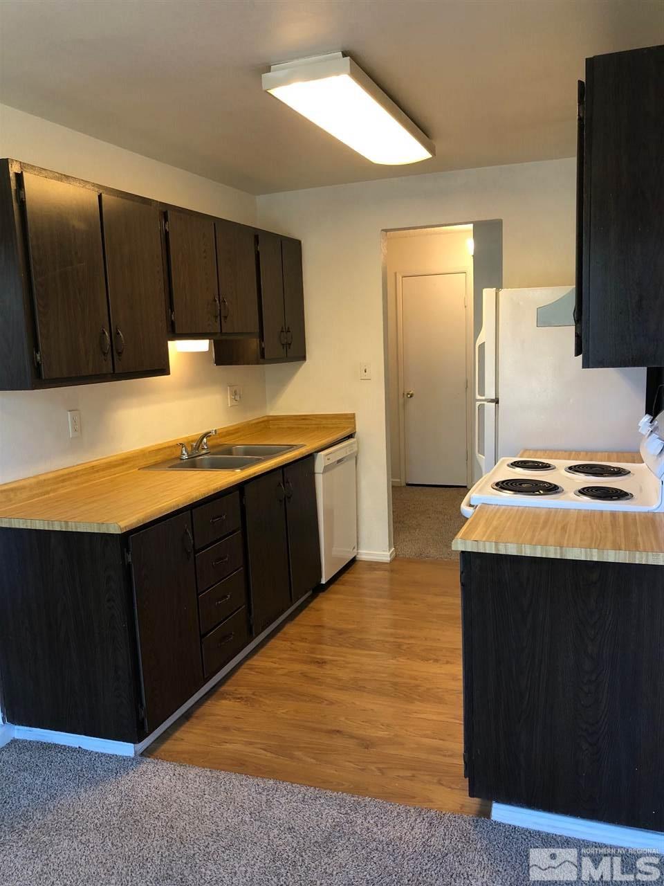 3942 Clear Acre Lane Reno, NV 89512 - Photo 6 of 24 a kitchen with a wooden floor and a refrigerator