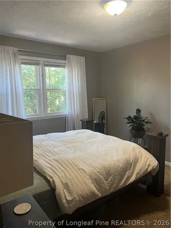 a bed sitting in a bedroom next to a window