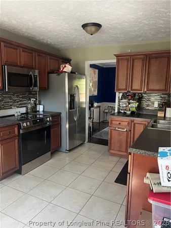 a kitchen with a sink a stove a refrigerator and cabinets